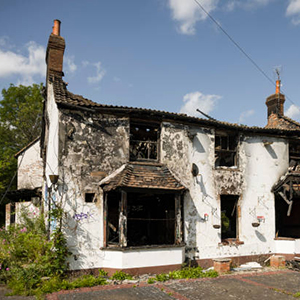 Buckinghamshire, UK - August 10, 2021. Fire damaged house. Building with burnt down roof and blackened walls.